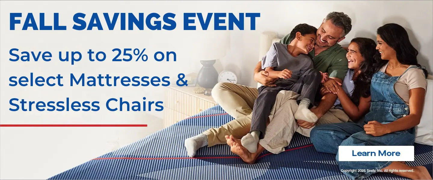 Family sitting on a mattress with promotional text for a fall savings event on mattresses and stressless chairs.