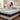 Woman sitting on a mattress in a bright bedroom