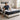 Man sitting on a mattress in a bright bedroom